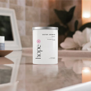 White cylindrical candle with silver lid, labeled "hope" and "doctor aromas," placed on reflective marble surface. - Candle | Amore - Amore - Doctor Aromas
