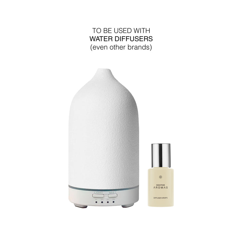 White ceramic ultrasonic diffuser with small beige bottle of holiday-scented diffuser drops. - Diffuser Drops | Holiday - Holiday - Doctor Aromas