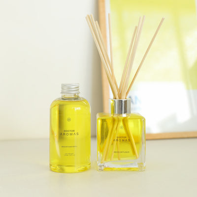 Glass square reed diffuser with yellow oil and matching refill bottle on light surface. - Oil Reed Diffuser & Refill Bundle | Holiday - Holiday - Doctor Aromas