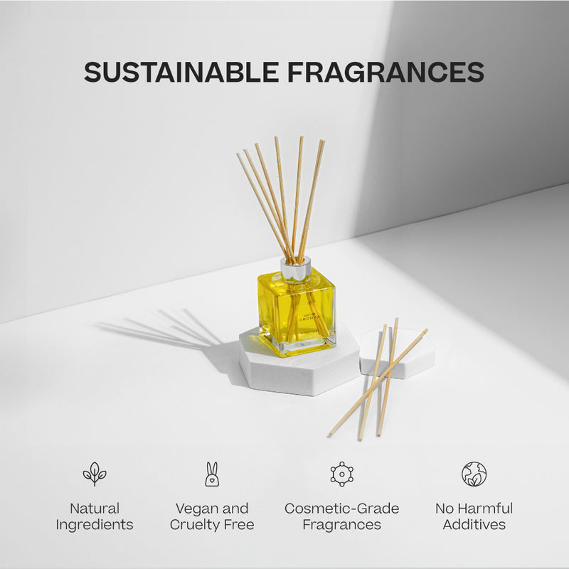 Yellow square glass oil reed diffuser with natural wooden reeds on white geometric pedestal under soft light. - Oil Reed Diffuser | Holiday - Holiday - Doctor Aromas