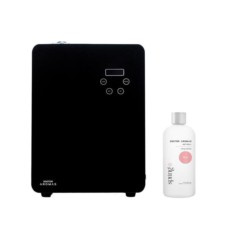 Black rectangular aroma diffuser with digital control panel beside white essential oil bottle labeled blush.