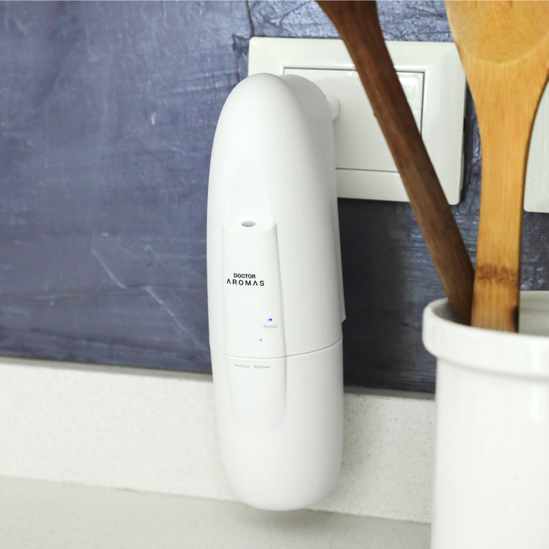 White sleek air freshener mist refill plugged into wall outlet next to wooden kitchen utensils in white holder. - Mist Refill Twin Pack | Holiday - Holiday - Doctor Aromas
