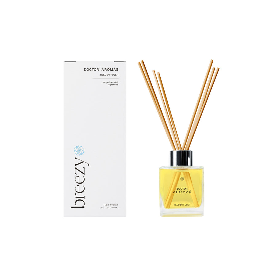 Breezy oil reed diffuser with yellow liquid in clear square glass bottle and wooden reeds, white vertical box with black text.