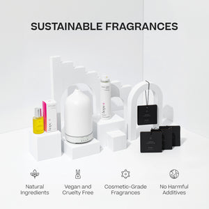 White sleek diffuser with curved top, yellow essential oil bottle, and black packaging, displayed on white geometric blocks. - The Gift of HOPE® Deluxe - White - Doctor Aromas