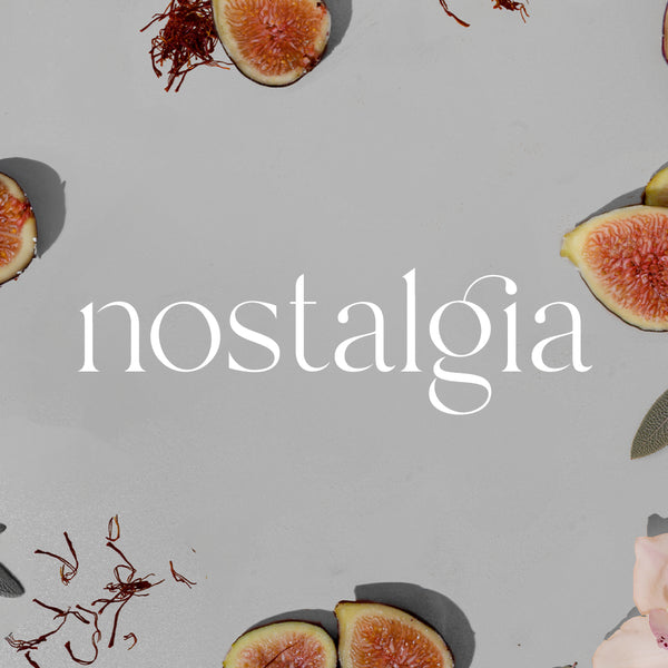 Gray background with sliced figs and pink flower petals surrounding the white Nostalgia logo. - Portable Scent Diffuser | Nostalgia - Nostalgia / Black - Doctor Aromas