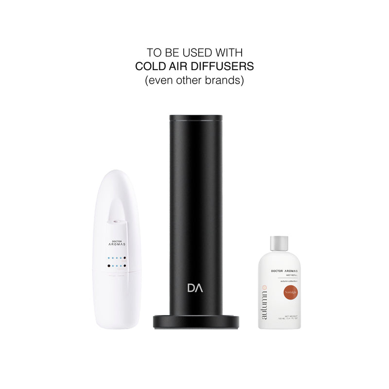 Black cylindrical cold air diffuser standing between a white remote and a small clear mist refill bottle with orange label. - Mist Refill Twin Pack | Nostalgia - Nostalgia - Doctor Aromas