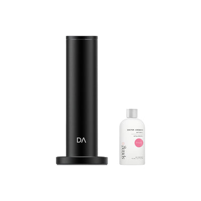 Black cylindrical aroma diffuser with wide base next to small white essential oil bottle labeled Pomelo. - Aroma Diffuser 500 | Pomelo - Pomelo / Black - Doctor Aromas