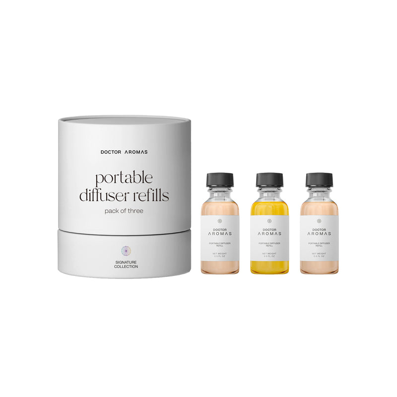 Set of three portable diffuser refill bottles with clear labels and black caps beside a white cylindrical storage container. - Portable Diffuser Refills Pack of Three | Signature Collection - Signature Collection - Doctor Aromas